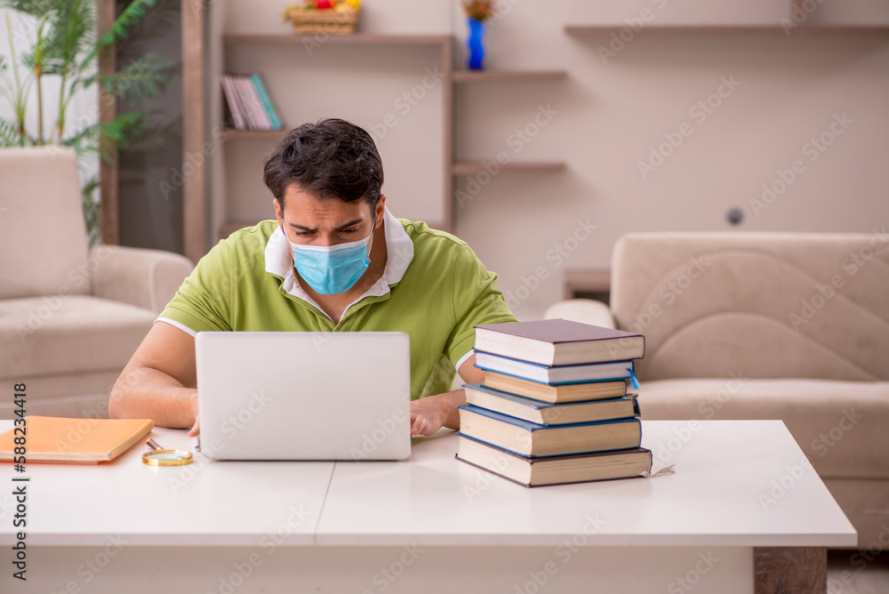 Young male student preparing for exams at home during pandemic Young male student preparing for exams at home during pandemic