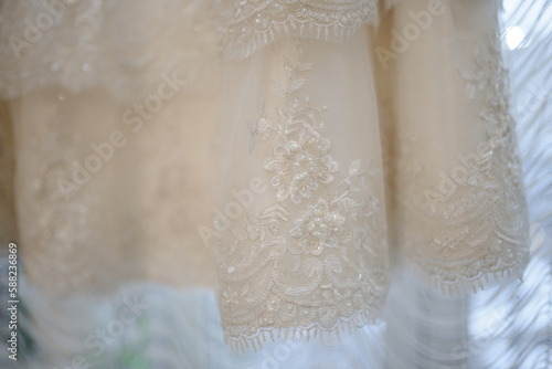 Part of an ivory wedding dress. French lace on the bride's dress with beads