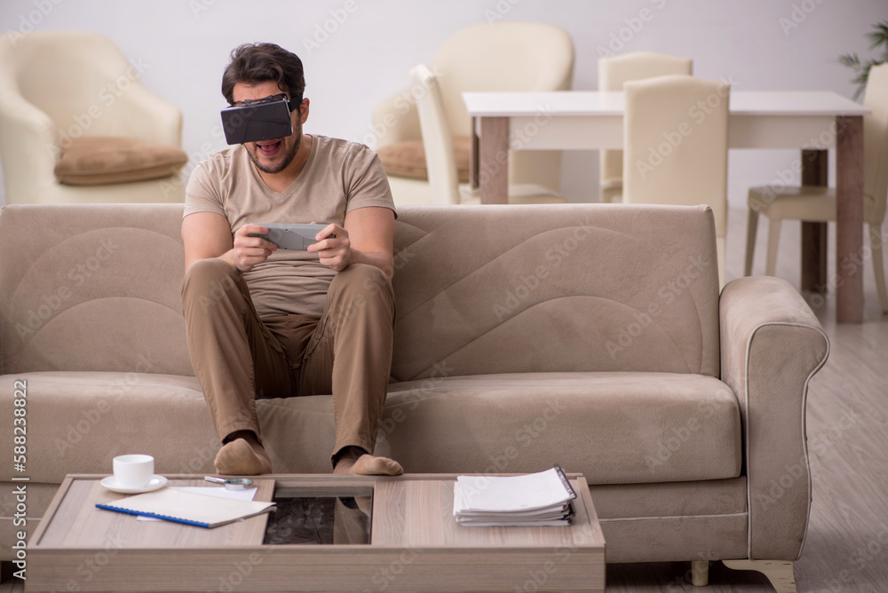 Obraz premium Young man enjoying virtual reality at home
