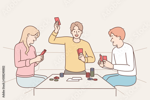 Group of friends playing poker sitting at table with chips enjoy gambling and relaxing together