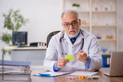 Old male doctor pharmacist in drugs synthesis concept