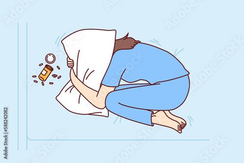 Depressed woman suffering from overdose of antidepressants covers head with pillow in need of qualified doctor help. Concept of overdose from drugs or prescription pills from psychotherapist 