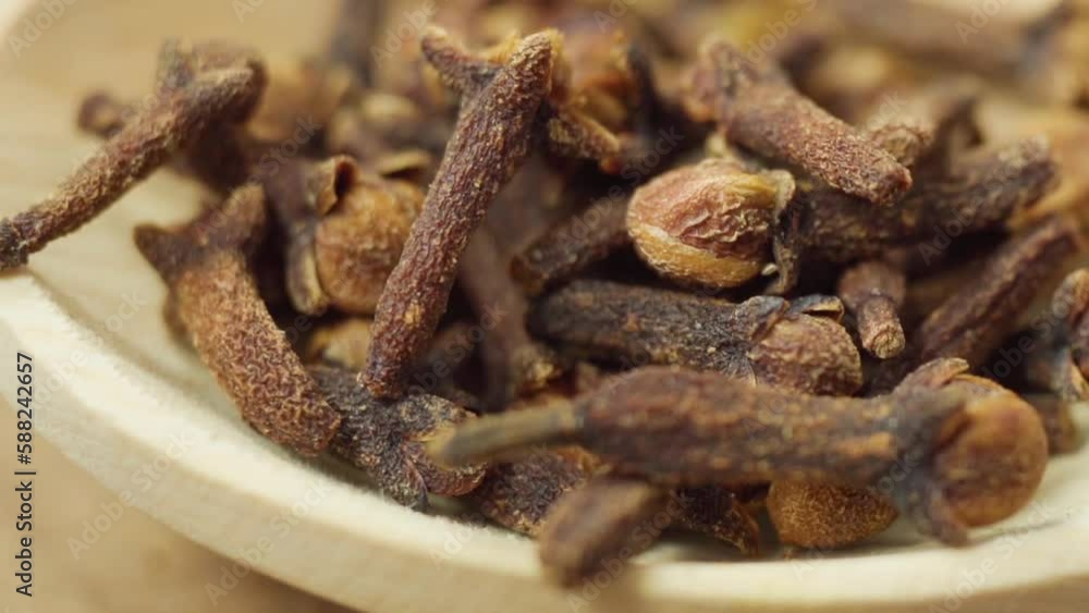 Dry cloves in wooden background. Cloves spice. Close up macro. Slow motion Dry cloves in wooden background. Cloves spice. Close up macro. Slow motion