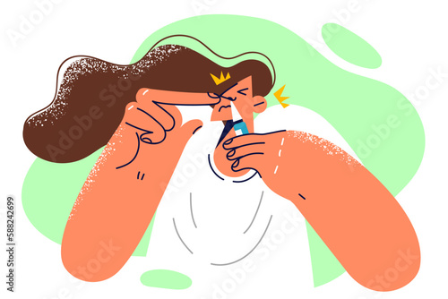 Woman is using runny nose spray during exacerbation of respiratory disease or attack of rhinitis