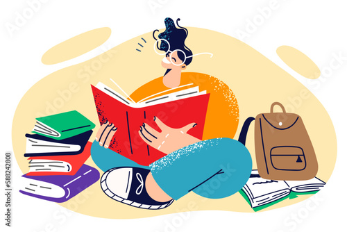 Young happy girl student sits on floor reading books and preparing for difficult exam