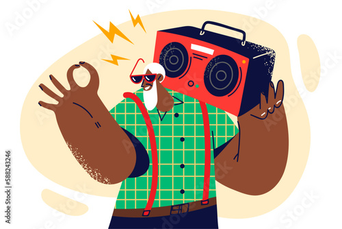 Gray-haired dark-skinned old man with tape recorder on shoulder smiles and shows OK gesture