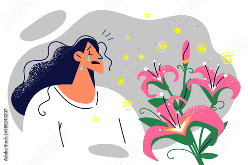 Sick woman cries because of allergy attack due to flowers with pollen and pungent odor
