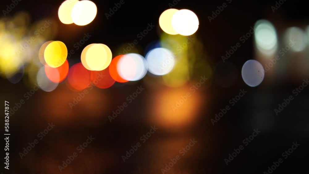 Blurred car lights bokeh in the evening city. Defocused headlights and street lighting at night. Moving bokeh circles of cars at night. Blurred city traffic background Blurred car lights bokeh in the evening city. Defocused headlights and street lighting at night. Moving bokeh circles of cars at night. Blurred city traffic background