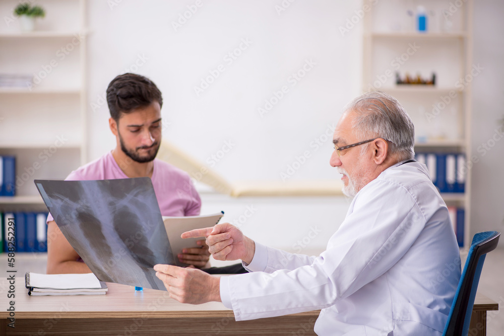 Young male patient visiting old male doctor radiologist Young male patient visiting old male doctor radiologist