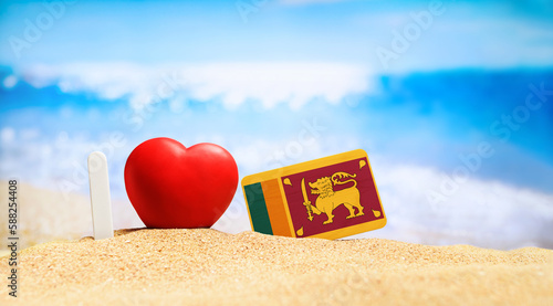 I love Sri Lanka. Flag of Sri Lanka on the beach with a red heart. vacation and travel concept.