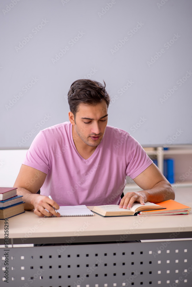 Young male student preparing for exams in the classroom Young male student preparing for exams in the classroom