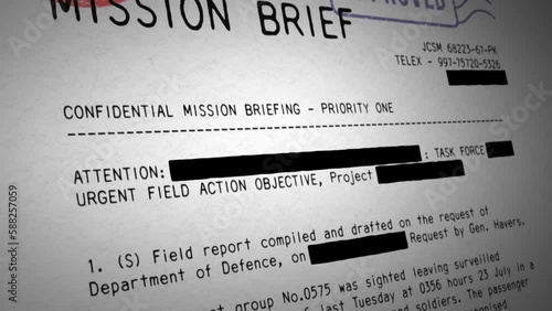 Camera tilts down a classified military document while black stripes begin to redact sections of the typewritten text