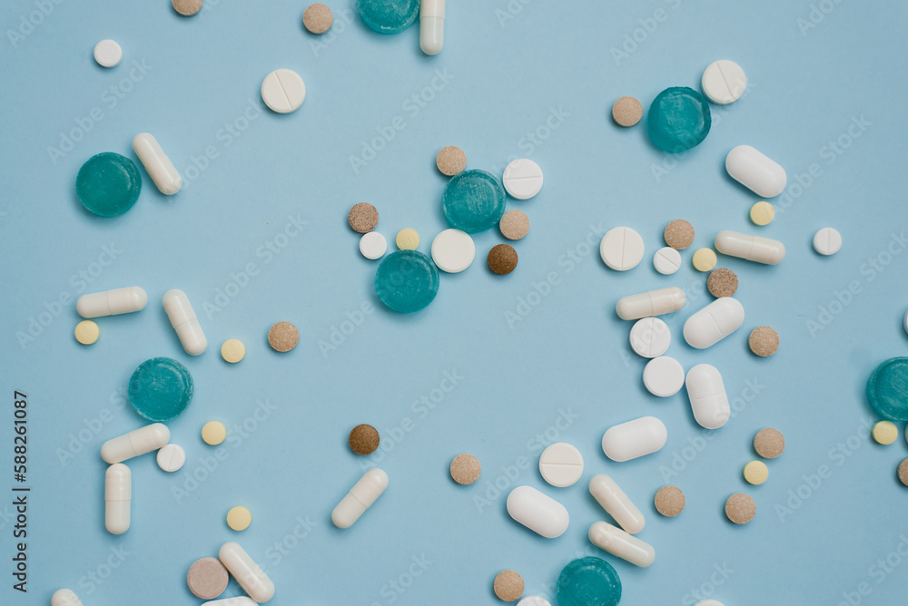 Tablets in bulk are multicolored on a blue background. The concept of medicine, pharmacy. Tablets in bulk are multicolored on a blue background. The concept of medicine, pharmacy.