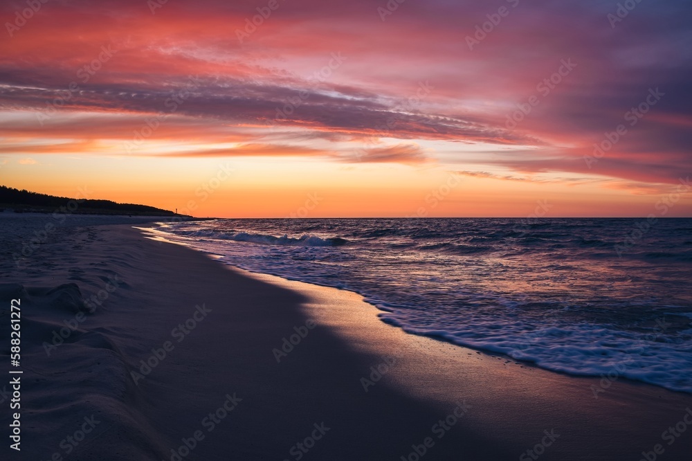 Fototapeta premium Beautiful colorful landscape on the beach by the sea. Sunrise over the Baltic Sea in Jastarnia, Poland.