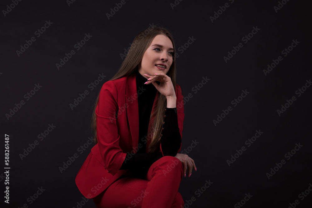 Portrait of a businesswoman in a red suit on a black background. Portrait of a businesswoman in a red suit on a black background.