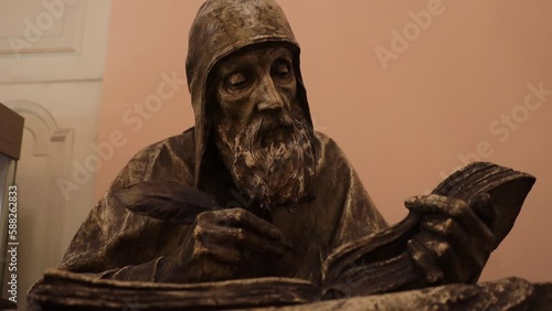 Russia Saint Petersburg 03.03.2023 Statue of a monk writing with a pen in a book photo