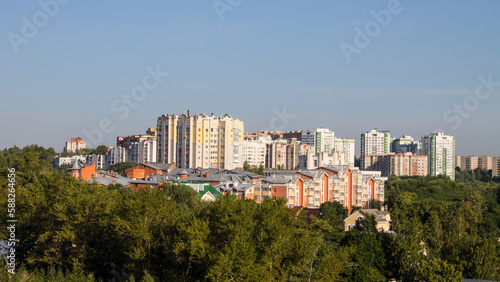Panoramic top view of the modern houses of the residential area of the city of Vladimir in Russia and a park with lush green foliage of trees on a sunny summer day