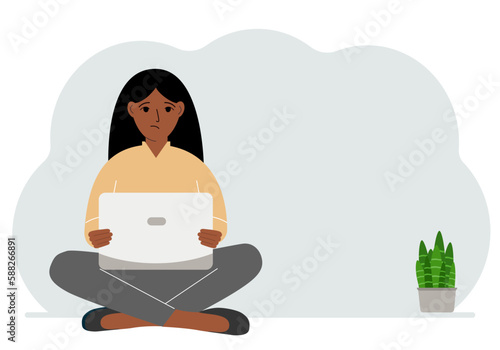 A woman sits cross-legged in his hands holding a laptop. The concept of work, education, reading, watching videos.