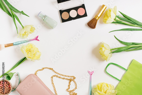 Decorative flat lay composition with make up products, cosmetics and flowers. Flat lay, top view on white background, copy space