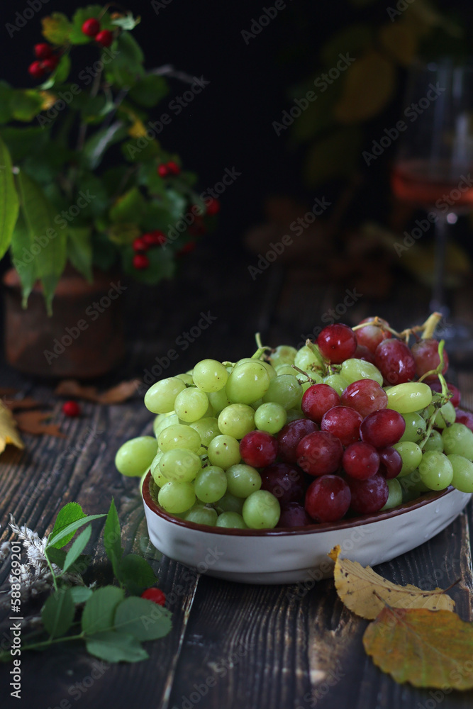 A bowl with red and green grape in rustic style	
