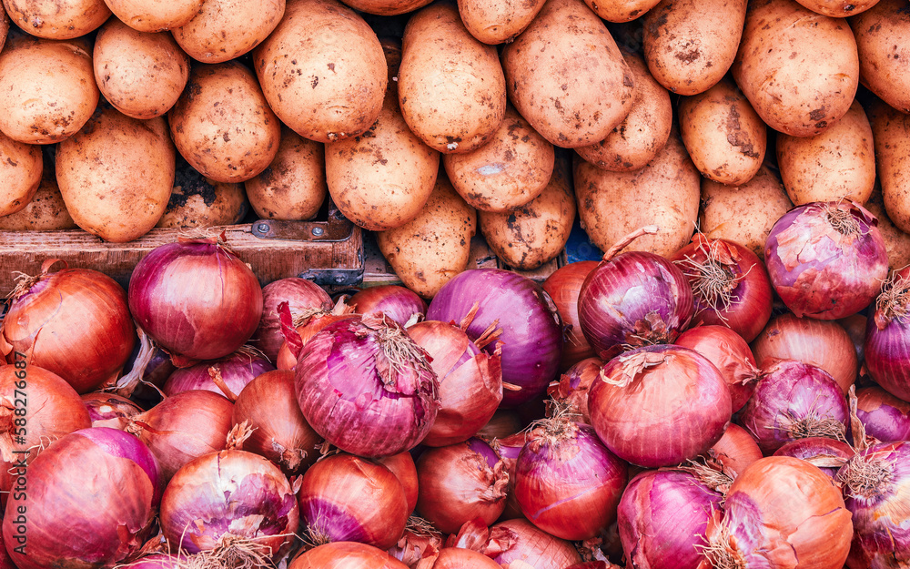 Organic potatoes and dry onions for sale at the local market. Vegan food background. Organic potatoes and dry onions for sale at the local market. Vegan food background.