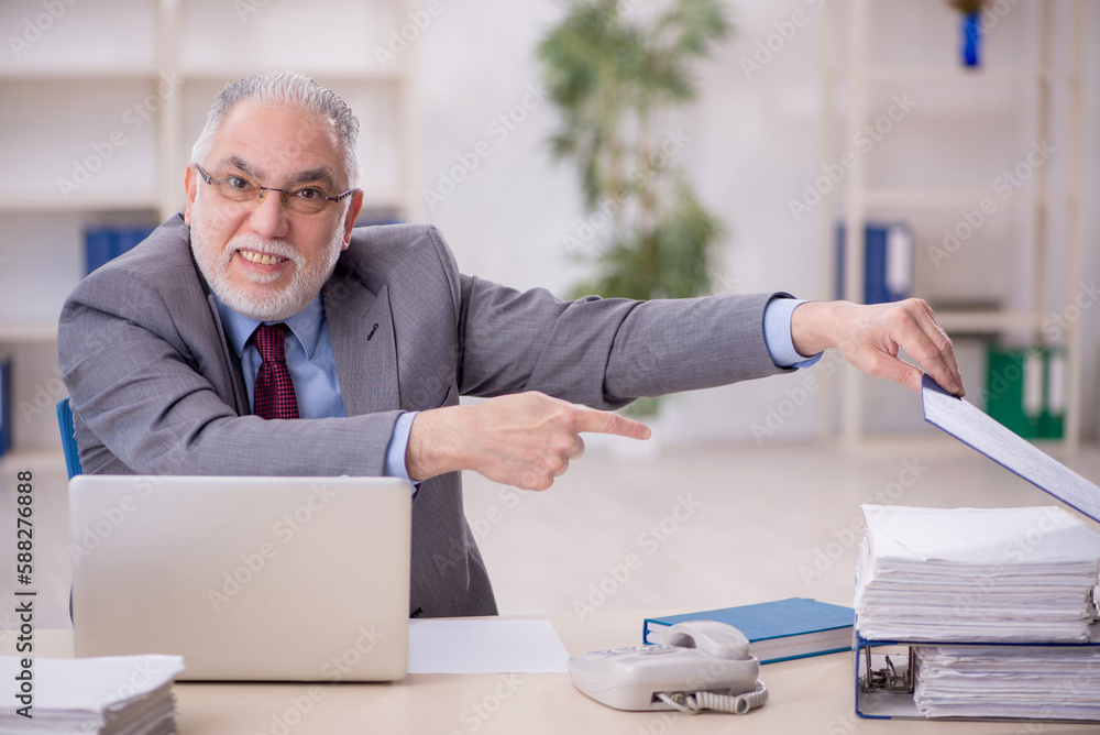 Old male employee working in the office Old male employee working in the office