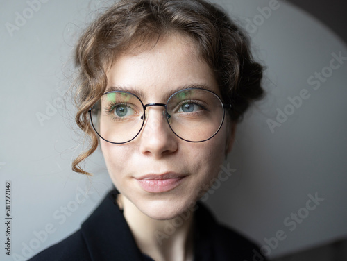 face portrait of a teenage girl 18 -19 years old, schoolgirl, college student. cute young smart woman in glasses, thinks, looks away. Real people, everyday life. Selective focus