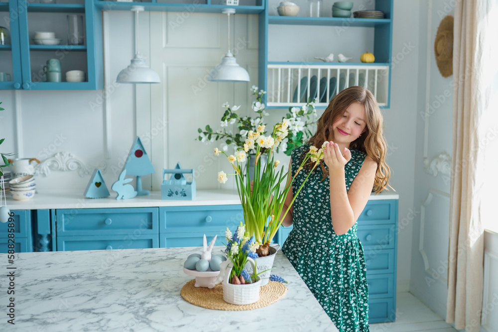 beautiful teenage girl standing in kitchen bright spring room decorated for Easter, green flowers, bunny figurine and colored eggs. Easter concept beautiful teenage girl standing in kitchen bright spring room decorated for Easter, green flowers, bunny figurine and colored eggs. Easter concept