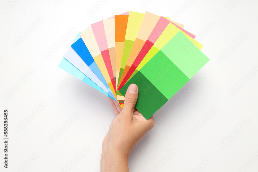 Female hand holding color palettes on white background Stock Photo ...