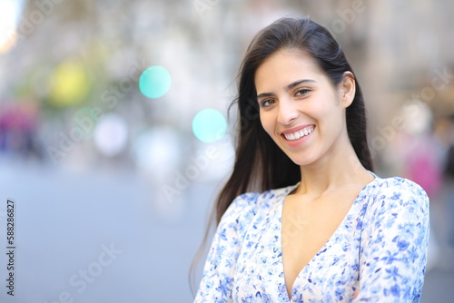 Happy woman posing looking at camera in the street