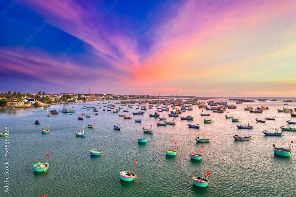 Aerial view of Mui Ne fishing village in sunset sky with hundreds of boats anchored to avoid storms, this is a beautiful bay in central Vietnam Aerial view of Mui Ne fishing village in sunset sky with hundreds of boats anchored to avoid storms, this is a beautiful bay in central Vietnam
