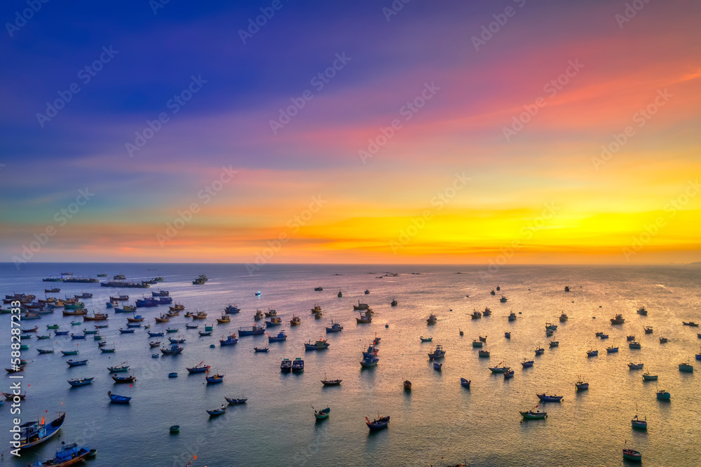 Aerial view of Mui Ne fishing village in sunset sky with hundreds of boats anchored to avoid storms, this is a beautiful bay in central Vietnam Aerial view of Mui Ne fishing village in sunset sky with hundreds of boats anchored to avoid storms, this is a beautiful bay in central Vietnam