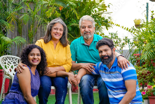 Happy indian family sitting together at outdoor.