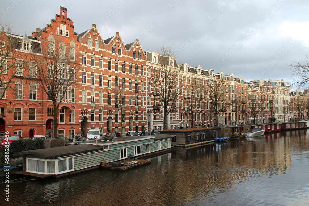canal and old brick houses or flat buildings in amsterdam (the netherlands)