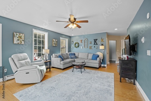 Εκτύπωση καμβά Beautiful suburban house interior with blue walls and sofas under a ceiling fan