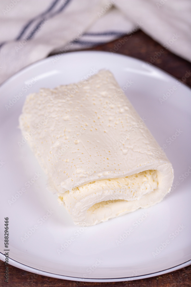 Clotted cream on wood background. Clotted cream (butter cream) for Turkish breakfast. local name inek kaymak. Close up Clotted cream on wood background. Clotted cream (butter cream) for Turkish breakfast. local name inek kaymak. Close up