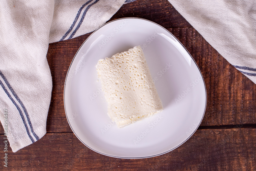 Clotted cream on wood background. Clotted cream (butter cream) for Turkish breakfast. local name inek kaymak. Top view Clotted cream on wood background. Clotted cream (butter cream) for Turkish breakfast. local name inek kaymak. Top view