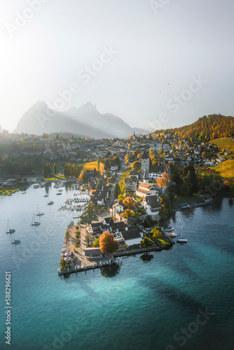 Aerial view of the harbour and castle of Spiez at late afternoon and sun dropping over the mountains, Lake Thun, Bern, Switzerland. photo