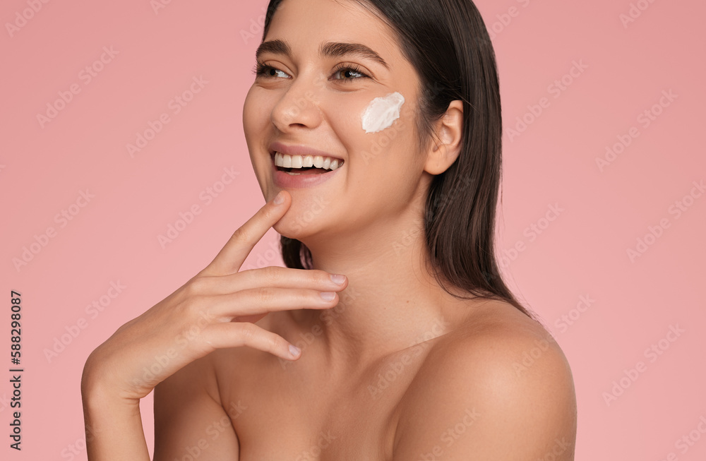 Happy woman with facial cream on cheek Happy woman with facial cream on cheek