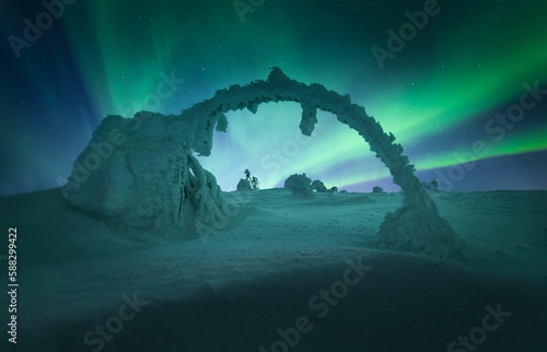 Snow-covered field under the beautiful Aurora Borealis sky
