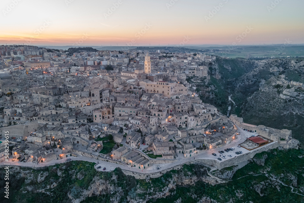 Aerial view of Sassi di Matera at sunset, an ancient old town along the mountain crest, Matera, Basilicata, Italy. Aerial view of Sassi di Matera at sunset, an ancient old town along the mountain crest, Matera, Basilicata, Italy.
