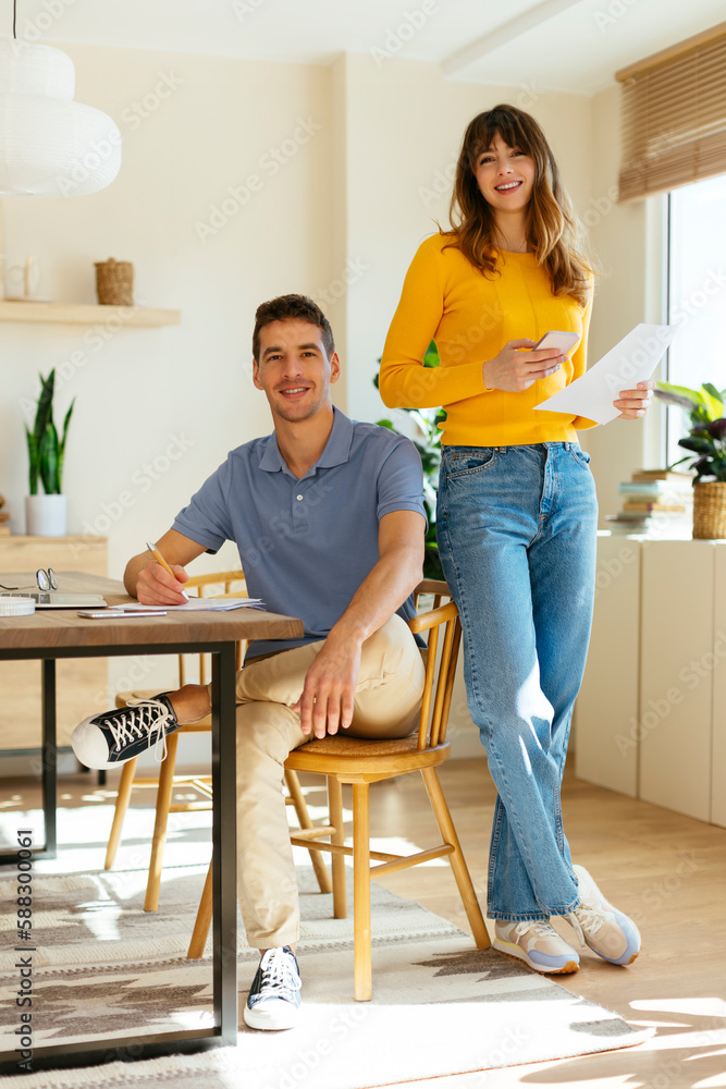Smiling freelancing couple at home office Smiling freelancing couple at home office