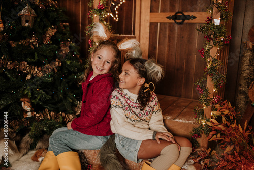 Smiling sisters sitting together at Christmas photo