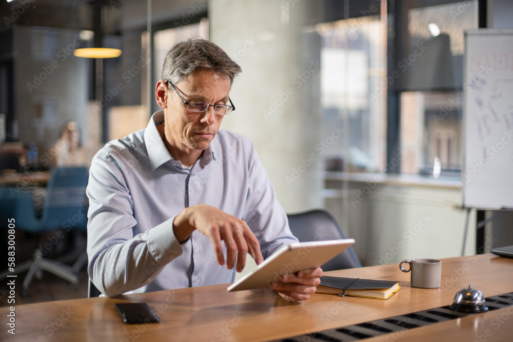 Portrait of businessman in office. Man using digital tablet. Businessman having video call Portrait of businessman in office. Man using digital tablet. Businessman having video call