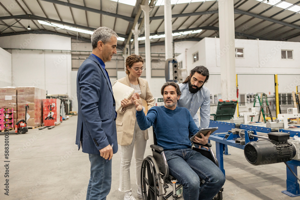 Disabled engineer having discussion with colleagues in industry Disabled engineer having discussion with colleagues in industry