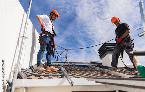 Wallpaper Mural Technicians wearing safety harness standing on roof Torontodigital.ca