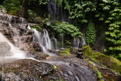 Long exposure shot of Banyumala waterfal with pile of stones