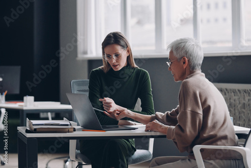 Confident financial advisor discussing options with senior woman in the office