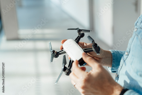 Businessman analyzing drone in corridor photo