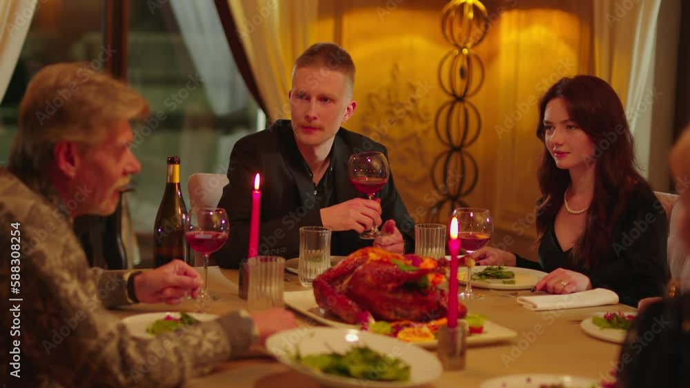 A young man, along with his girlfriend and parents, is having dinner at a restaurant. A friendly family drinks red wine and communicates sincerely during dinner at an expensive restaurant. A young man, along with his girlfriend and parents, is having dinner at a restaurant. A friendly family drinks red wine and communicates sincerely during dinner at an expensive restaurant.